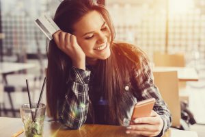 Young women in a cafe with credit card +++++ Note for the inspector : Credit card is fake +++++